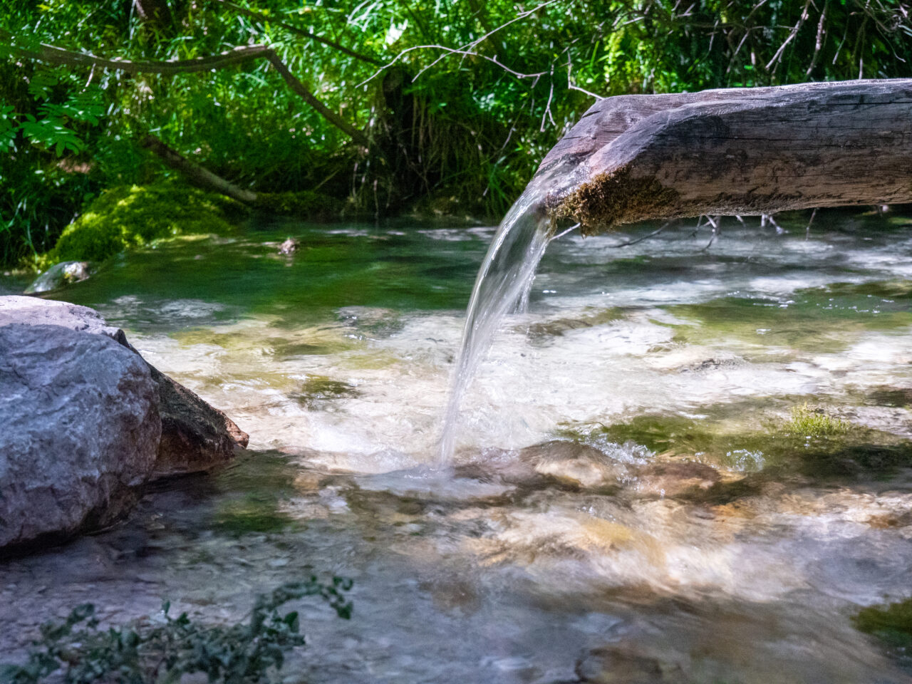 Wasser läuft aus einer Rinne beim Isar-Ursprung im Seefeld in Tirol